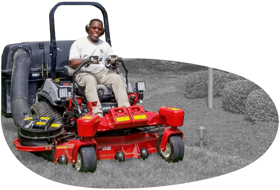 Marcus Williams, owner of Williams Lawn Care Services using a commercial lawn mower to mow the lawn of a client.